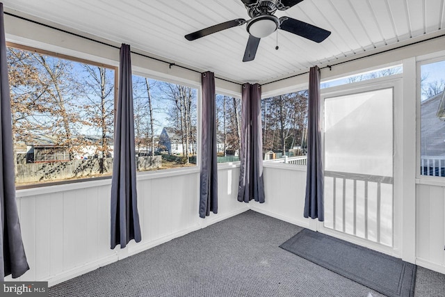 unfurnished sunroom featuring ceiling fan