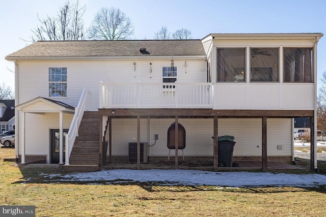 rear view of house with a wooden deck, a yard, central AC, and a sunroom