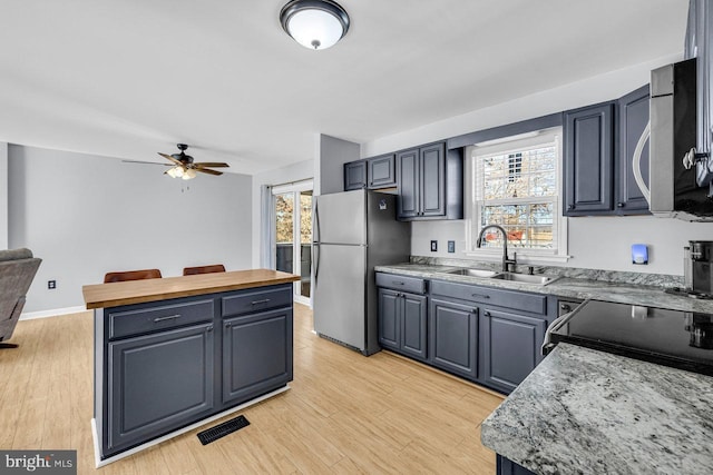 kitchen with plenty of natural light, appliances with stainless steel finishes, sink, and light wood-type flooring