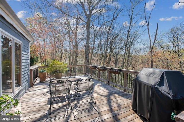 deck with grilling area and outdoor dining space