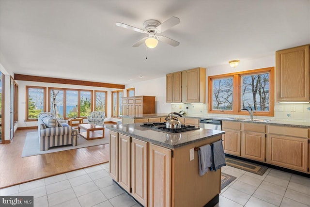 kitchen with a center island, a healthy amount of sunlight, a sink, and gas stovetop