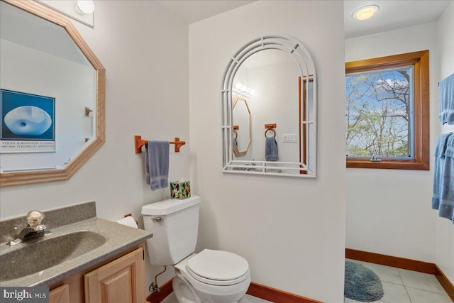 half bath with baseboards, tile patterned floors, toilet, and vanity