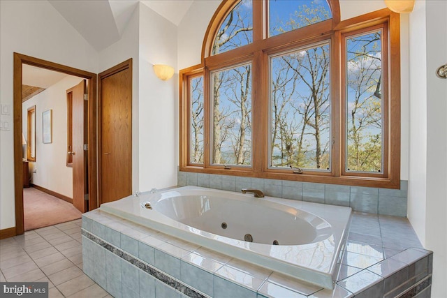 full bathroom featuring baseboards, a whirlpool tub, lofted ceiling, and a wealth of natural light
