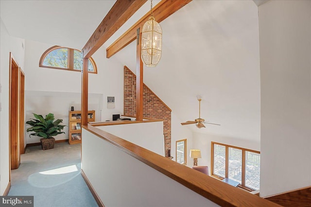 corridor featuring plenty of natural light, high vaulted ceiling, and beamed ceiling
