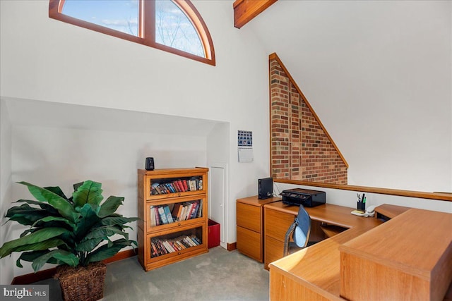 carpeted office with lofted ceiling with beams