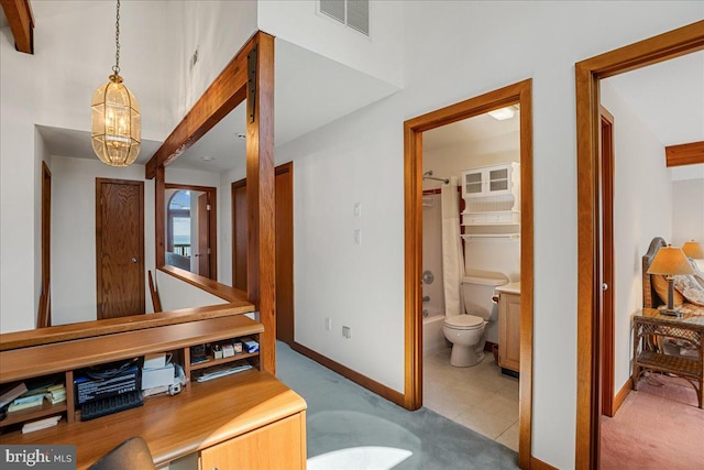 hallway featuring an inviting chandelier, baseboards, carpet flooring, and visible vents
