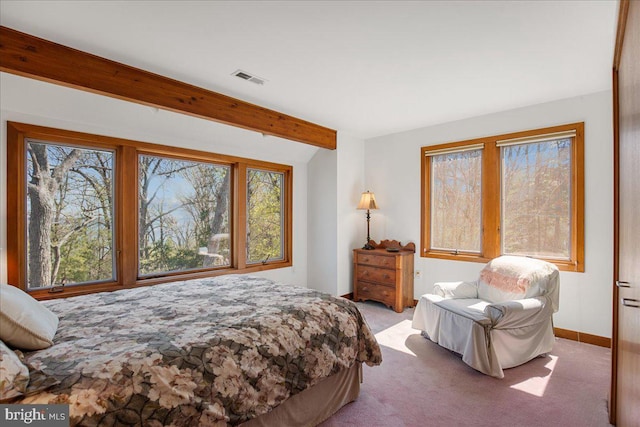 carpeted bedroom with visible vents, multiple windows, and vaulted ceiling with beams