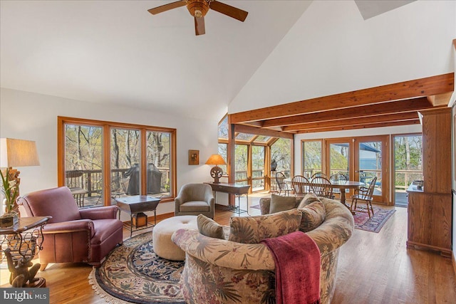 living room featuring high vaulted ceiling, beamed ceiling, a ceiling fan, and wood finished floors
