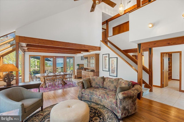 living room featuring stairway, high vaulted ceiling, a ceiling fan, and wood finished floors