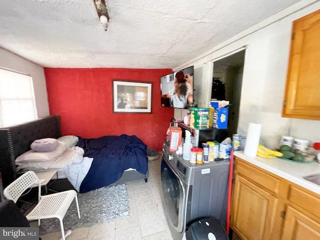 bedroom with washer / clothes dryer, a textured ceiling, and light tile patterned floors