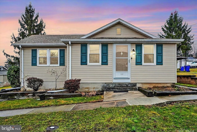 bungalow-style house with a lawn