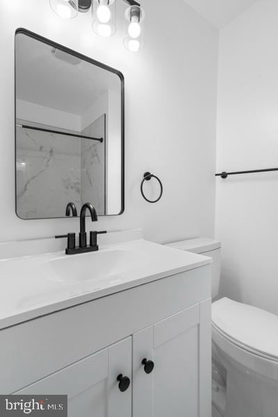 bathroom featuring vanity, toilet, and a tile shower