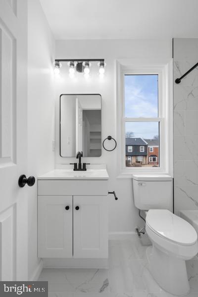 bathroom featuring vanity, toilet, and tiled shower