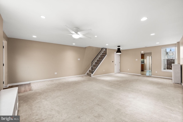 unfurnished living room featuring light carpet and ceiling fan