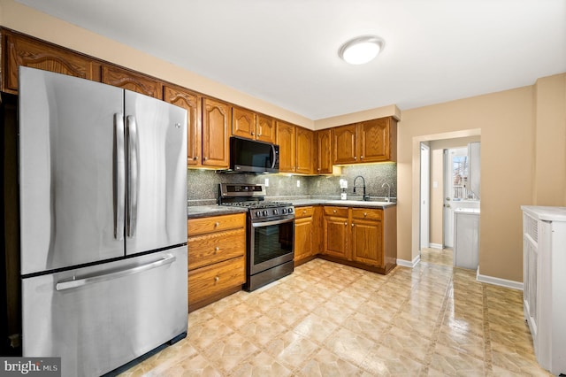 kitchen with stainless steel appliances, sink, and decorative backsplash