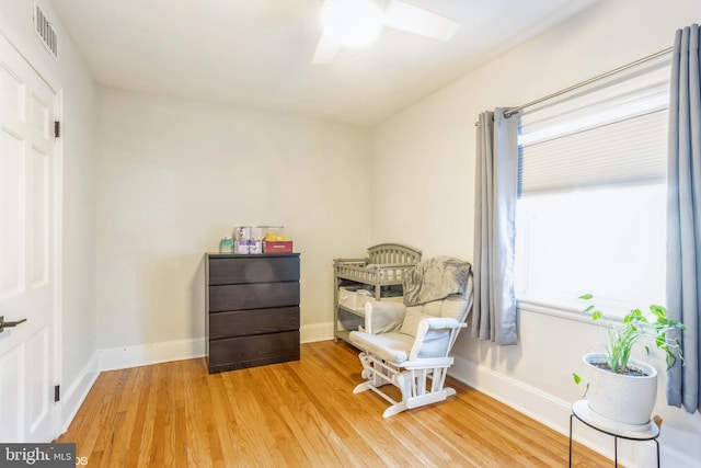 living area with ceiling fan, hardwood / wood-style floors, and a wealth of natural light