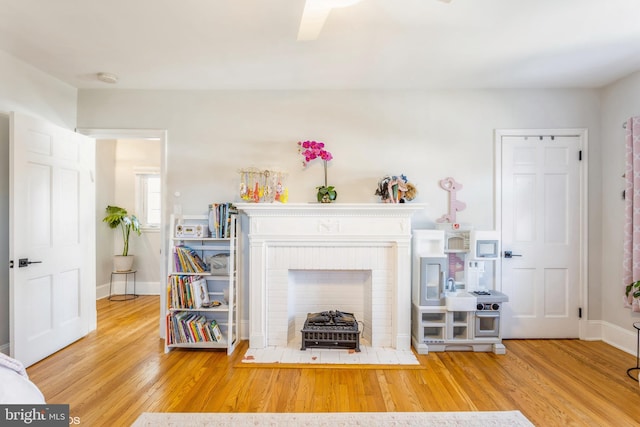 living room featuring hardwood / wood-style flooring and a brick fireplace