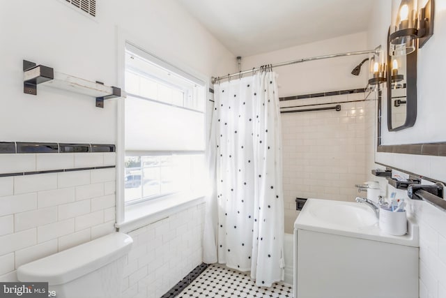 full bathroom with tile walls, shower / tub combo, vanity, and toilet