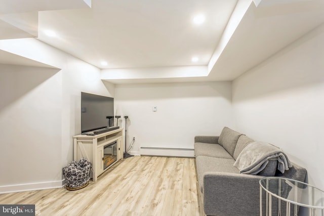 living room featuring baseboard heating and light hardwood / wood-style floors