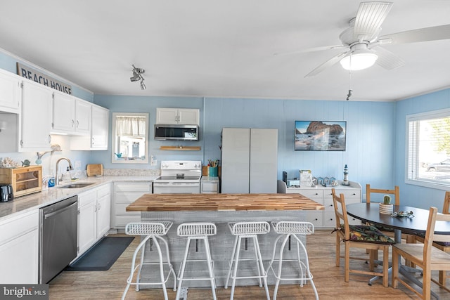 kitchen with white cabinetry, appliances with stainless steel finishes, sink, and dark hardwood / wood-style floors