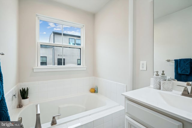 bathroom featuring vanity and tiled bath