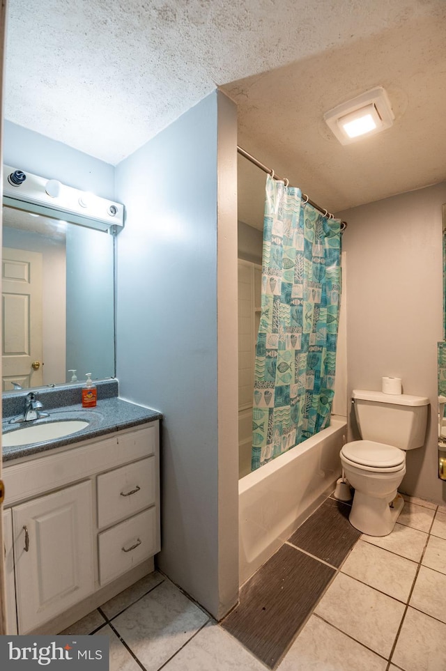 full bathroom with shower / bath combo, vanity, a textured ceiling, tile patterned floors, and toilet