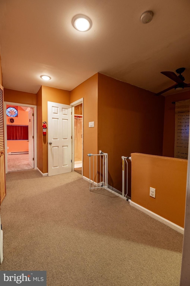 corridor featuring a baseboard radiator and light carpet