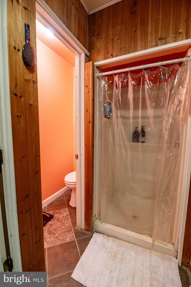 bathroom with a shower with shower curtain, wood walls, and toilet