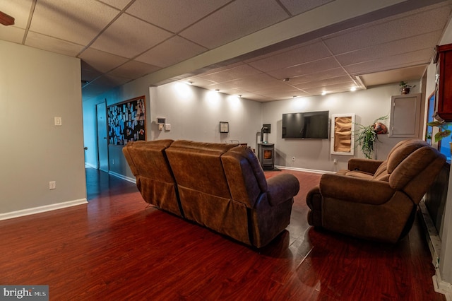 home theater room with a paneled ceiling and dark hardwood / wood-style flooring