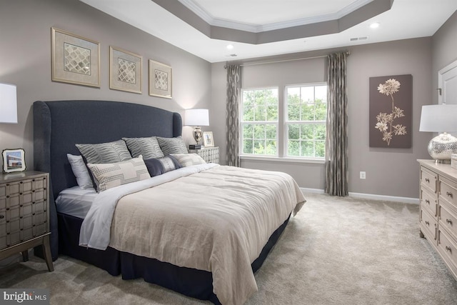 bedroom featuring a raised ceiling, crown molding, and light carpet