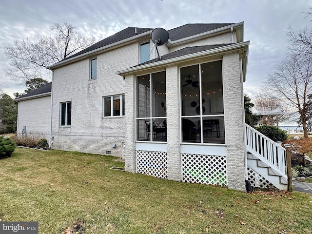 back of house featuring a sunroom, a yard, and ceiling fan