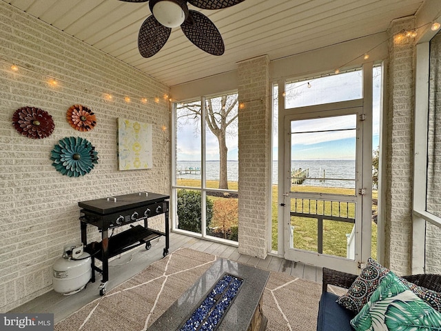 sunroom / solarium featuring a water view and wooden ceiling