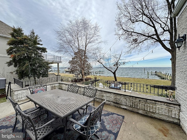 view of patio / terrace featuring central AC unit and a water view