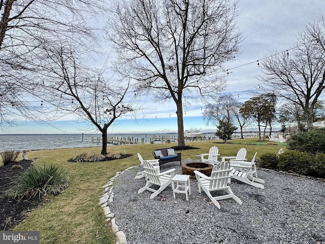 view of yard featuring a water view and a fire pit