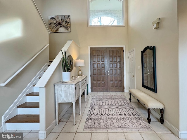 foyer with light tile patterned floors and a high ceiling