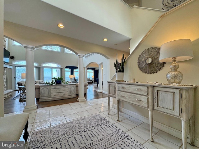 interior space with ornate columns, a high ceiling, and light tile patterned floors