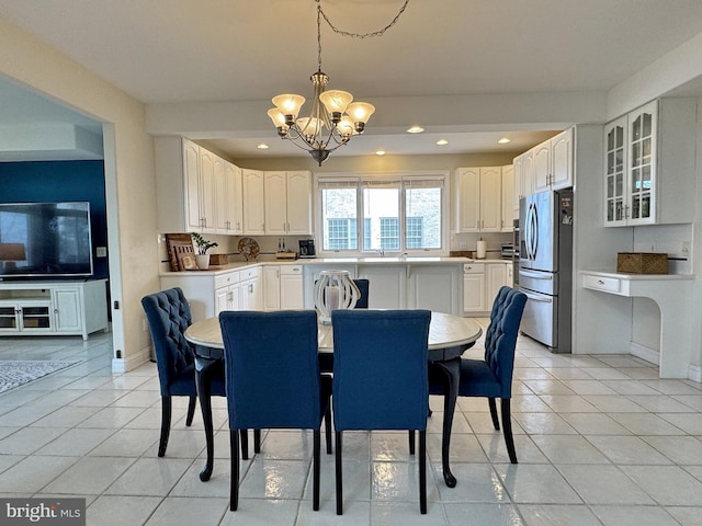 tiled dining space featuring an inviting chandelier and sink