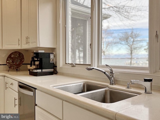 kitchen with a healthy amount of sunlight, sink, white cabinetry, and dishwasher