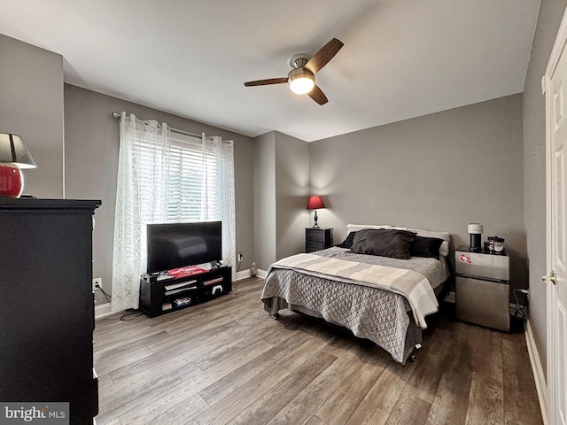 bedroom with stainless steel fridge, ceiling fan, and light hardwood / wood-style flooring