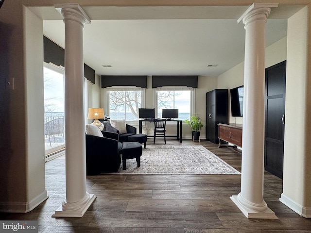 living room with dark wood-type flooring and decorative columns