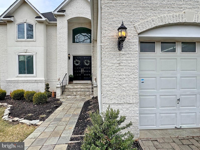 view of exterior entry with a garage and french doors