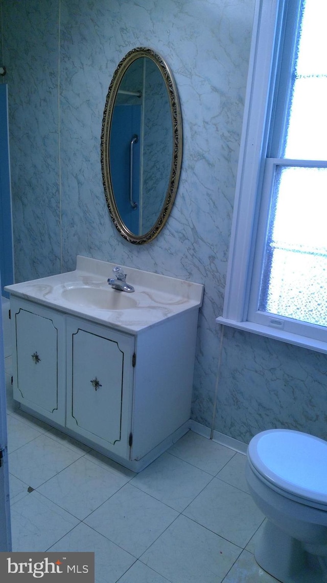 bathroom with tile patterned flooring, vanity, and toilet