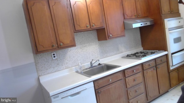 kitchen with tasteful backsplash, white appliances, sink, and extractor fan