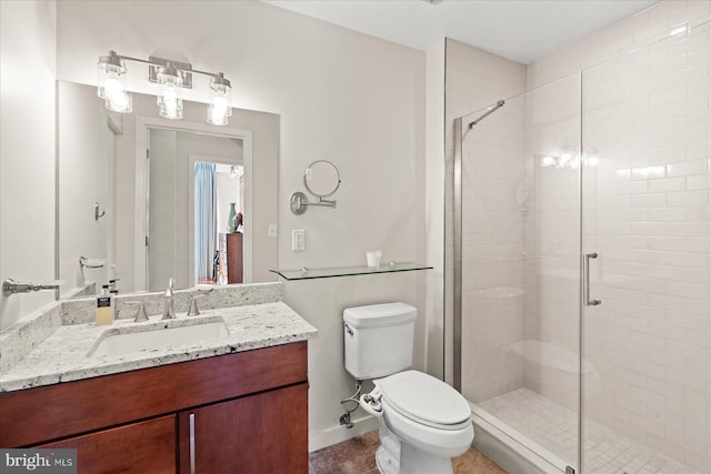 bathroom with vanity, toilet, and a stall shower