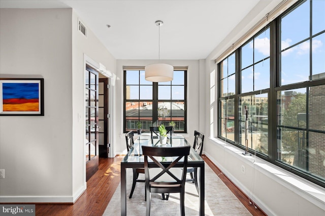 dining space featuring visible vents, baseboards, and wood finished floors