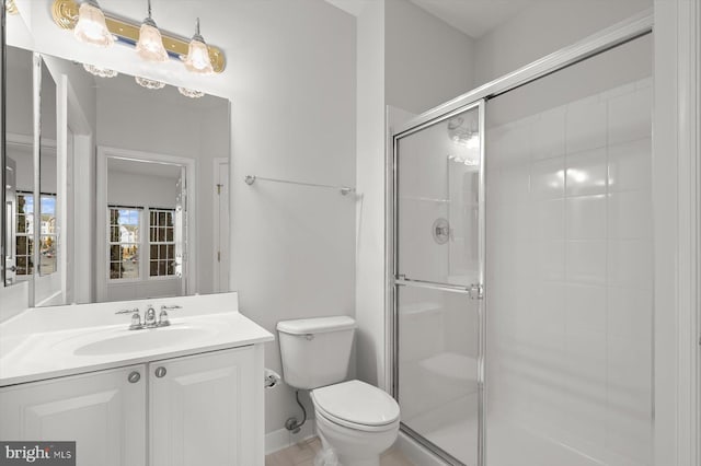 bathroom with vanity, toilet, and a shower with shower door