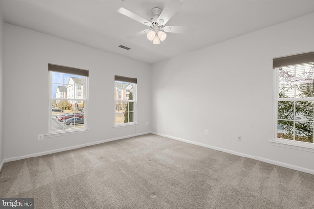 carpeted spare room with ceiling fan