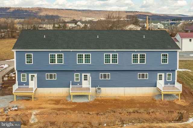 back of property featuring cooling unit and a mountain view