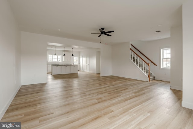 unfurnished living room with ceiling fan and light wood-type flooring