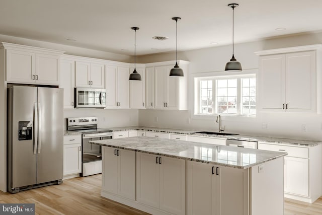 kitchen featuring stainless steel appliances, a center island, and white cabinets